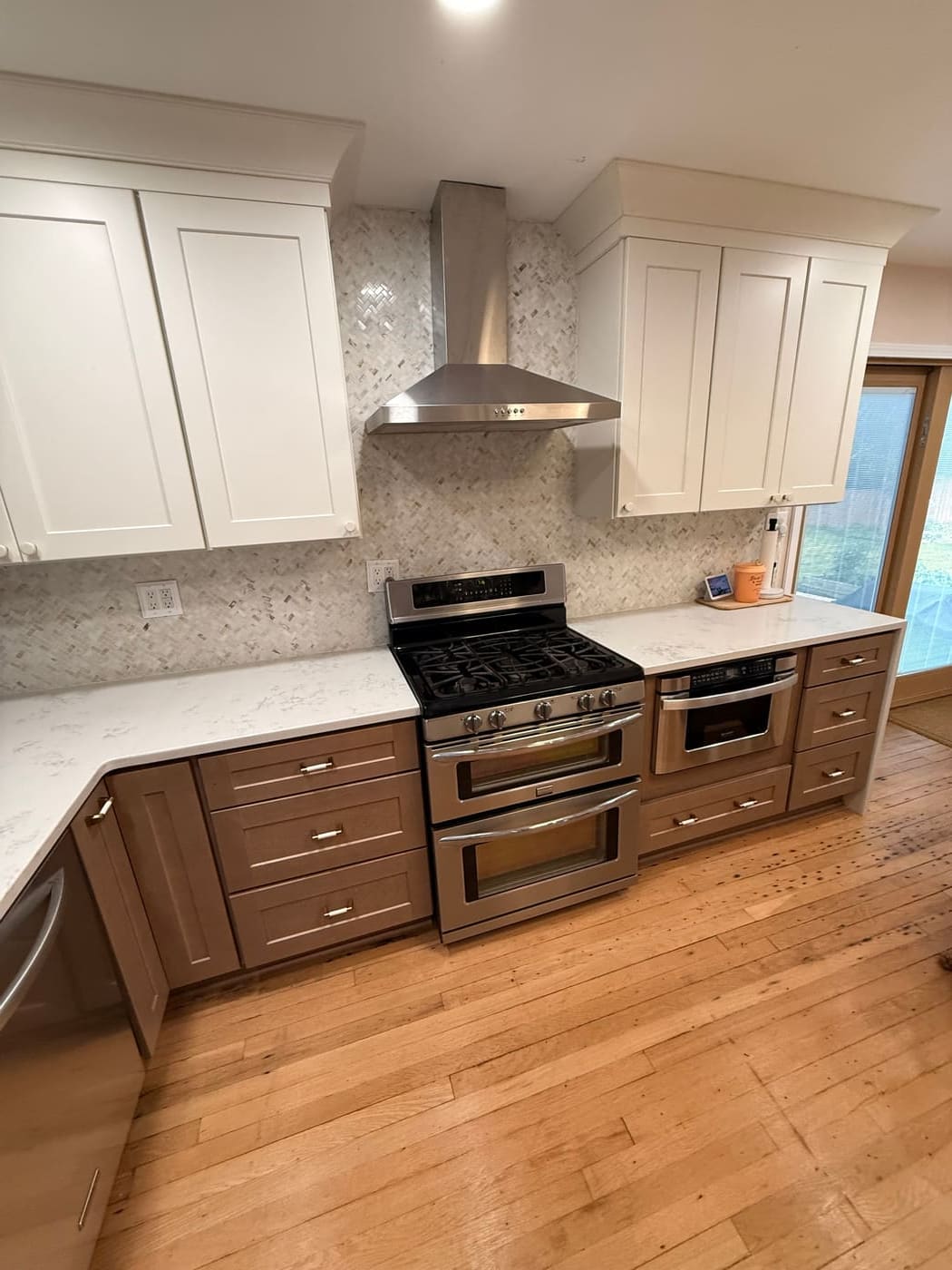 Full kitchen remodel with two-tone cabinetry and herringbone tile backsplash, a Renewed Construction kitchen remodeling project