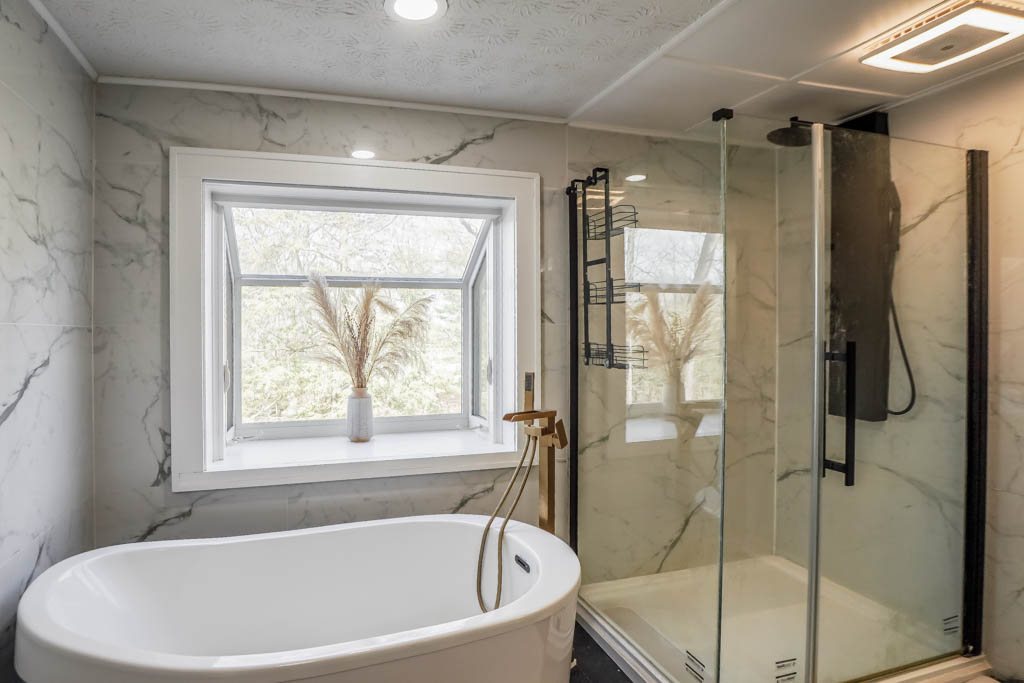 Freestanding tub and marble-look tile shower surround, a Renewed Construction bathroom remodeling project
